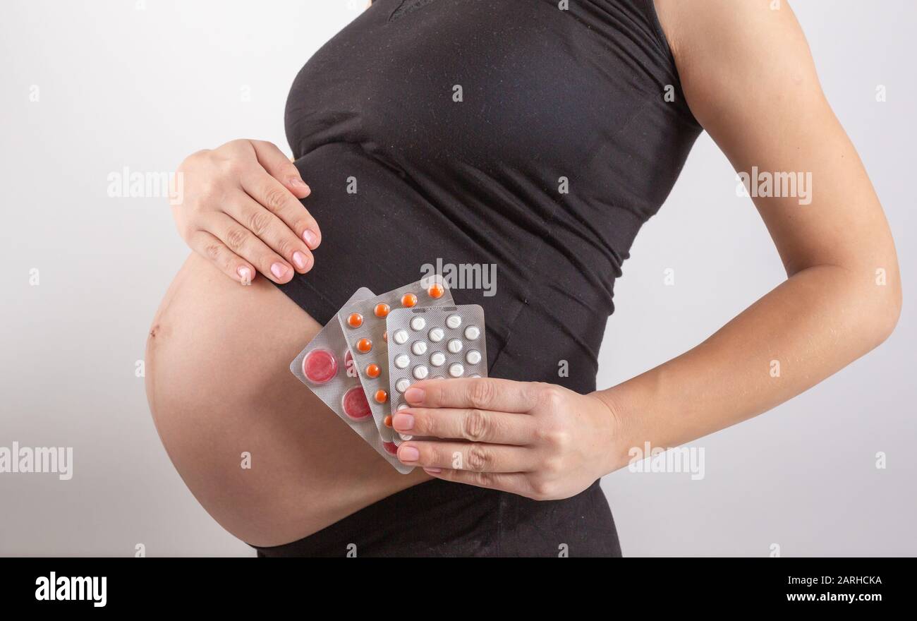 Schwangerschafts-, Menschen- und Gesundheitskonzept - Nahaufnahme von Schwangeren, Vitamine und Mineralstoffe für Schwangere. Medikamente während der Schwangerschaft nehmen Stockfoto