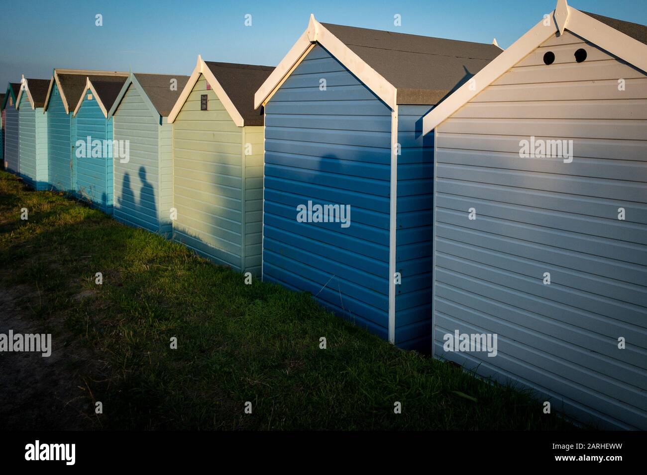 Strandhütten mit den Schatten einer Familie im Urlaub in Großbritannien Stockfoto