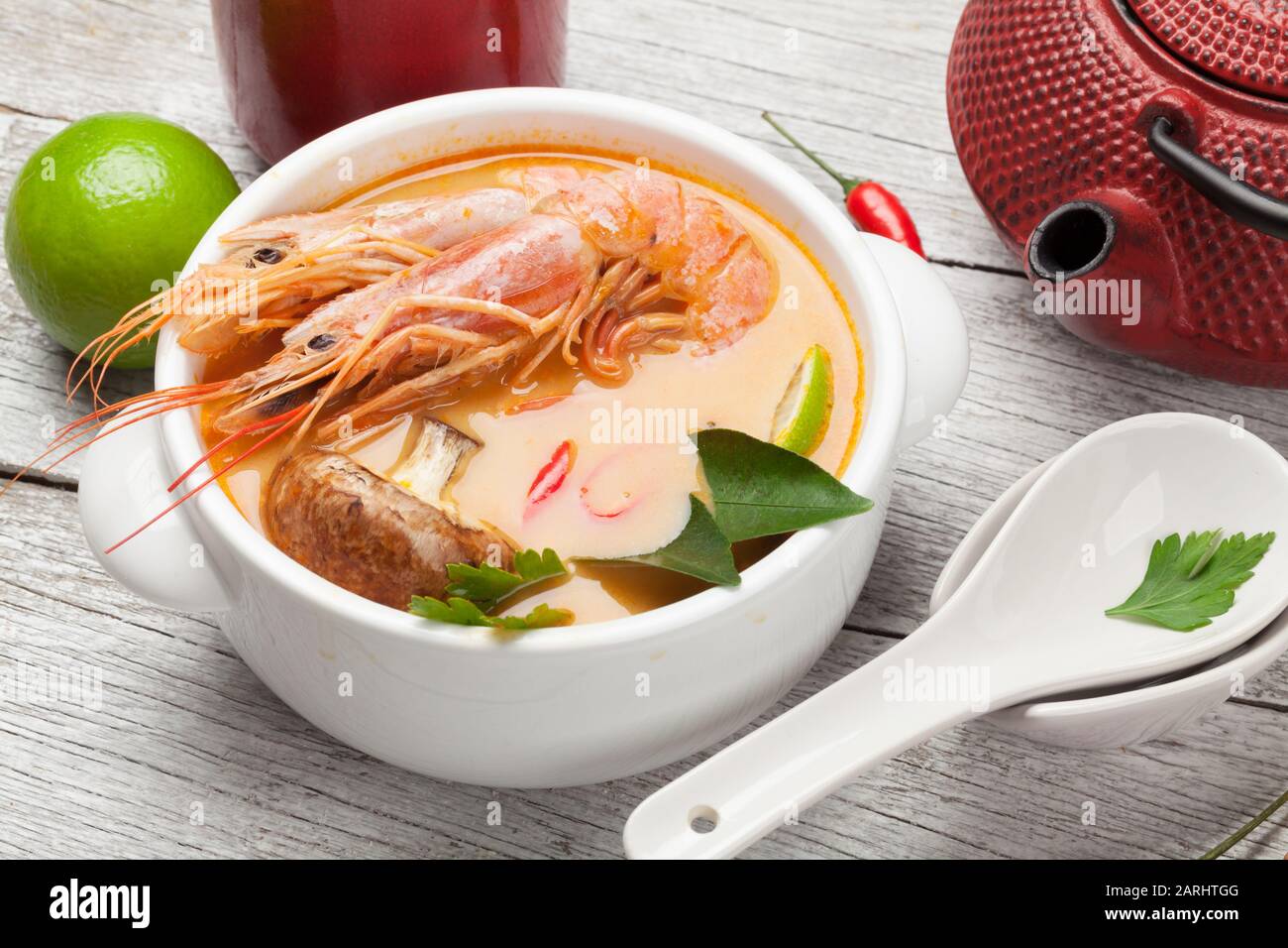 Tom Yum traditionelle thailändische Suppe mit Meeresfrüchten, Pilzen, Kokosmilch und heißen Gewürzen. Mit grünem Tee Stockfoto