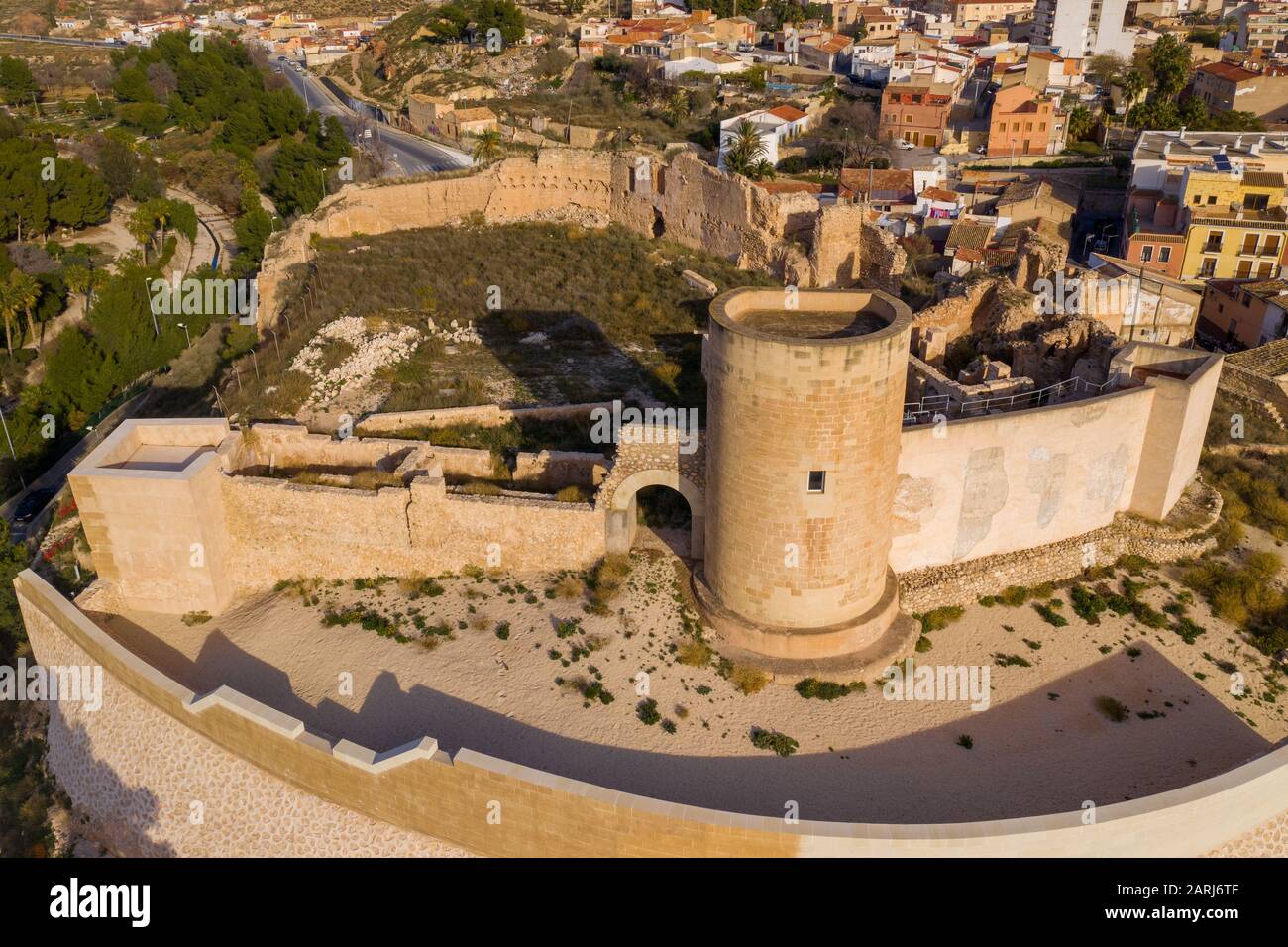 Luftpanorama über der mittelalterlichen Burg Elda mit teilweise restaurierten Mauern, Bergfried und Tor aus weißem Kalkstein in Spanien Stockfoto