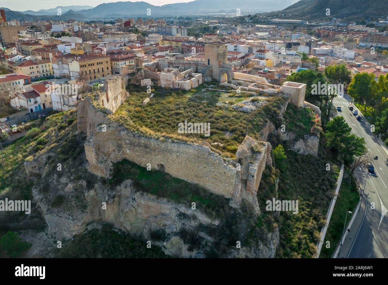 Luftpanorama über der mittelalterlichen Burg Elda mit teilweise restaurierten Mauern, Türmen und Tor aus weißem Kalkstein in Spanien Stockfoto
