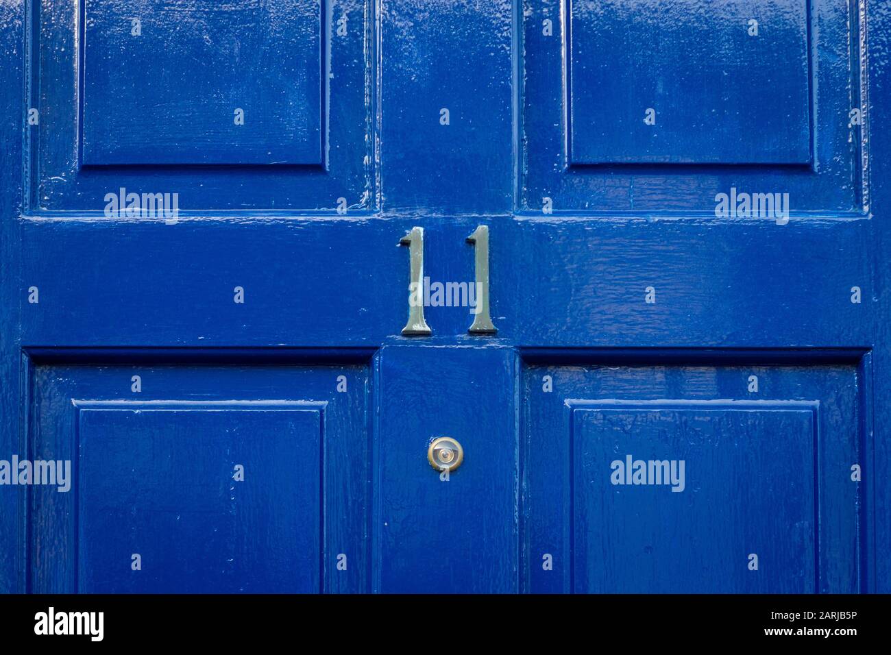 Haus Nummer 11 auf einer blauen Holztür Stockfoto