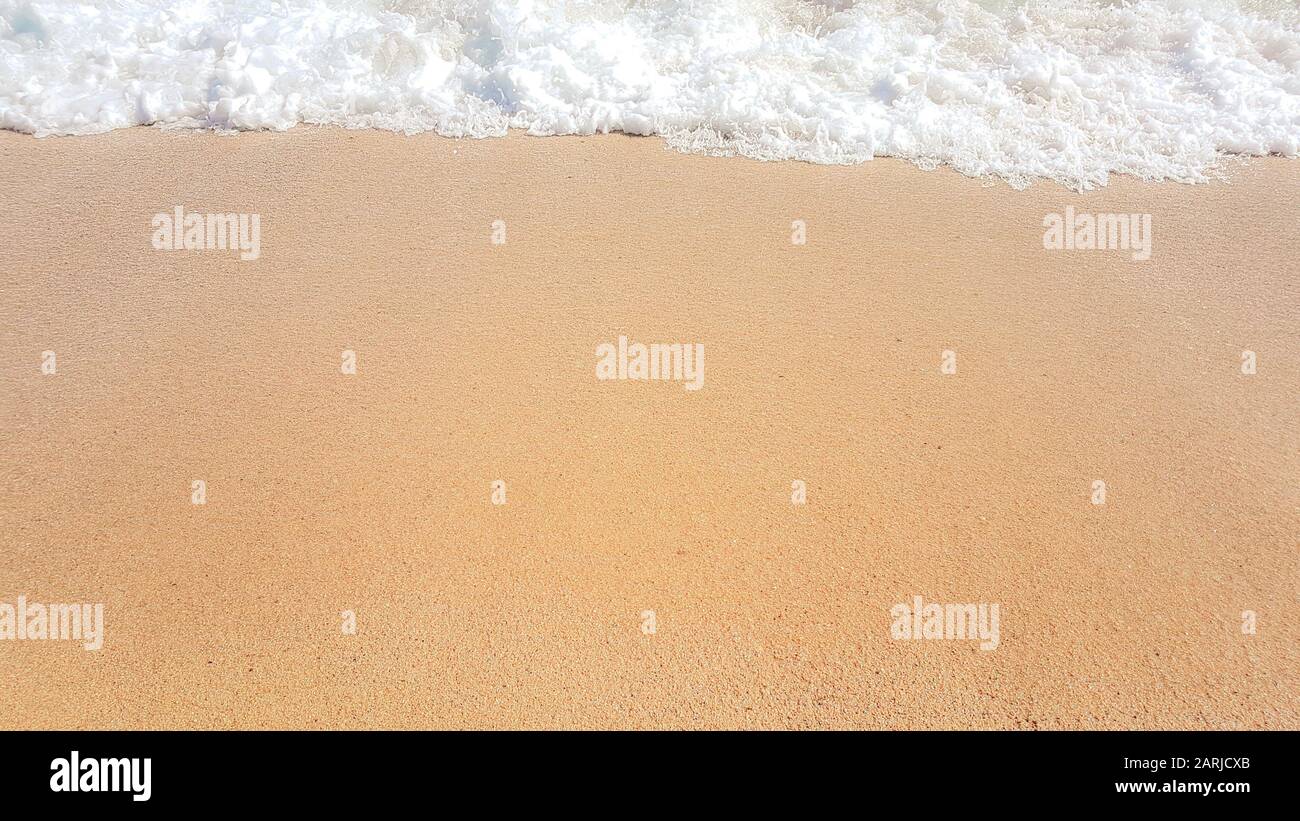 Zusammenfassung Hintergrund der Wellen im Meer, auf goldenen Sand, Weißes Meer Schaum. Stockfoto