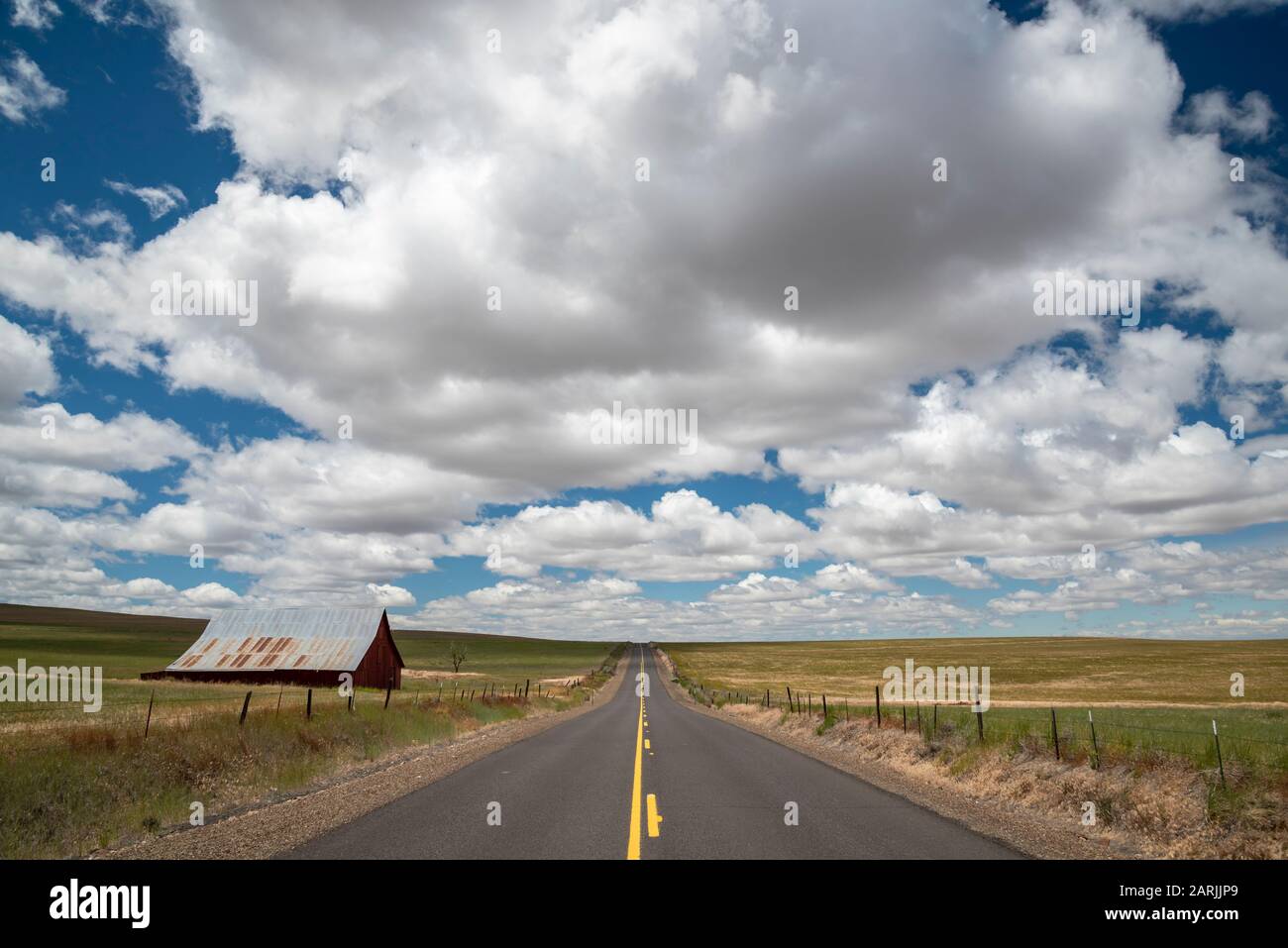Highway 206, cumulus Clouds und alte Scheune zwischen Condon und Hepner im Nordosten von Oregon. Stockfoto