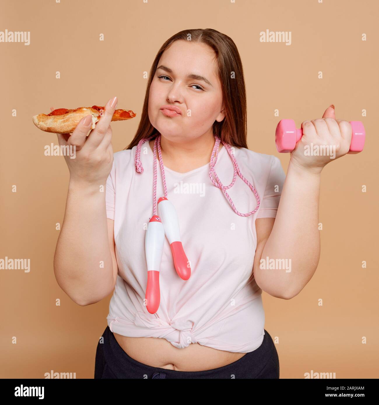 Übergewichtige Frau, die mit Überessen zu kämpfen hat. Fitness- und Diätkonzept Stockfoto