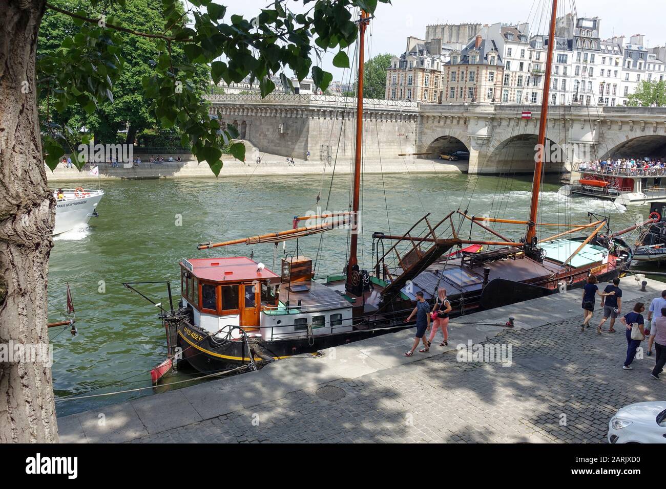 Arbeitsboot gefesselt auf Quai de Conti mit Pont Neuf im Hintergrund, St. Germain-des-Pres, Paris, Frankreich Stockfoto