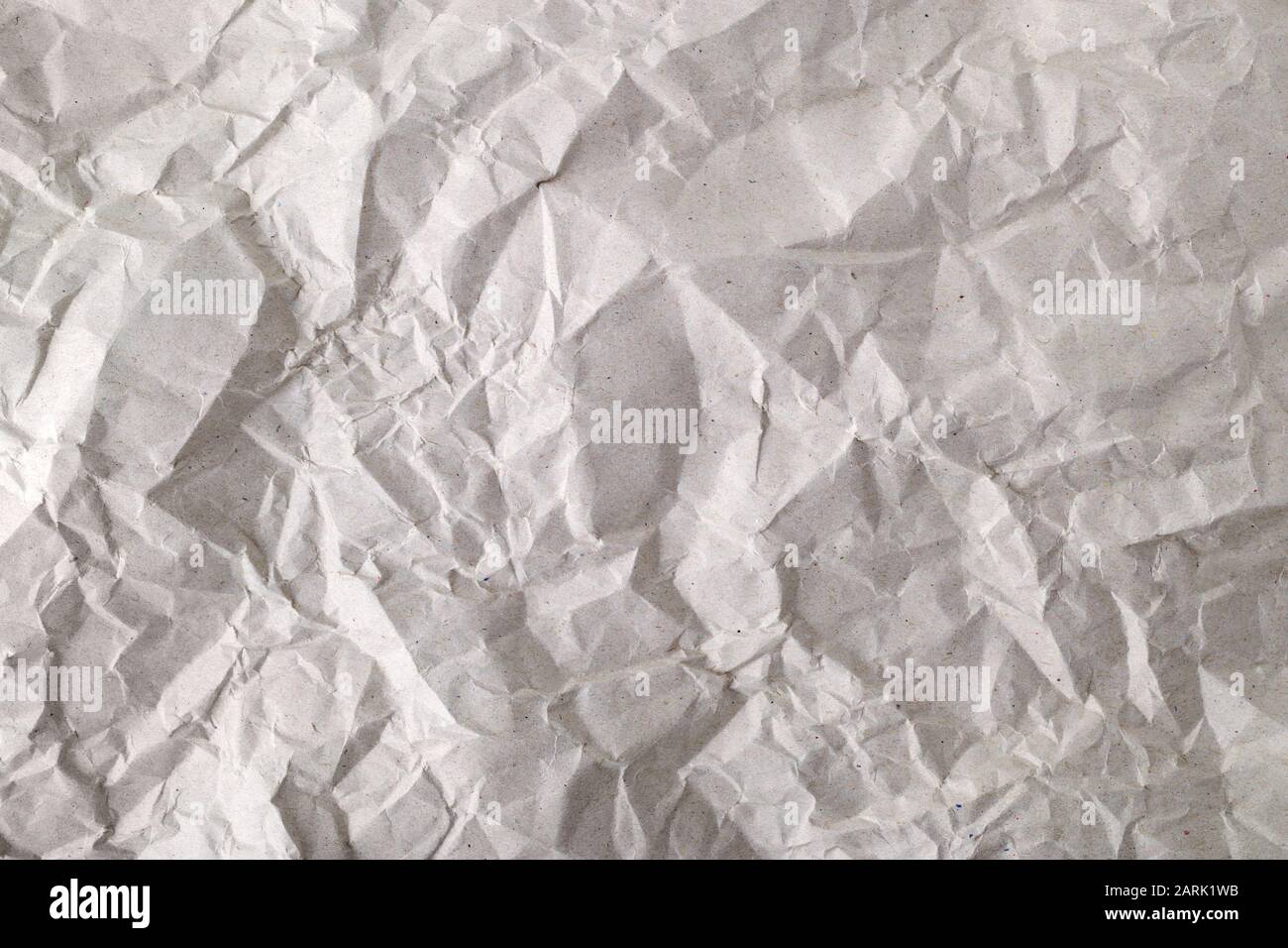 Textur des zerknitterten, grauen Verpackungspapiers. Hintergrund des zerknitteten Packpapiers. Leeres graues zerknittertes Papier. Kopierbereich. Draufsicht. Stockfoto