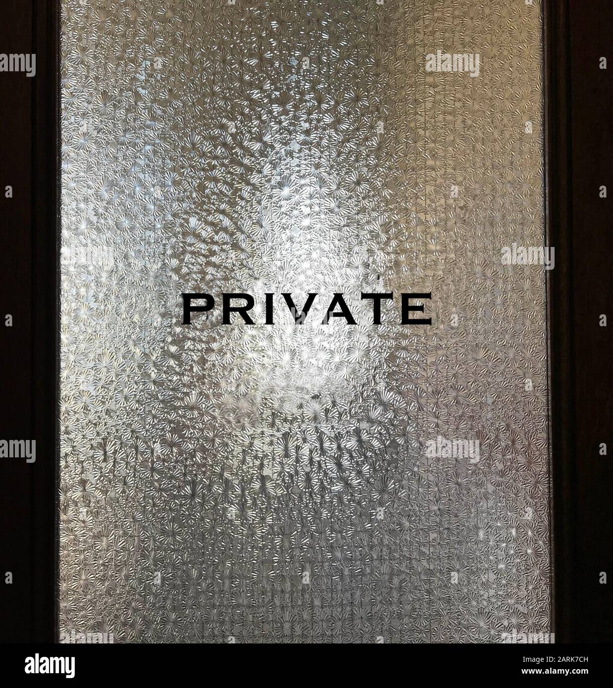 Eine Tür im Retro-Konferenzraum mit lichtundurchlässigem Glas mit dem Wort "privat" auf der Oberfläche Stockfoto