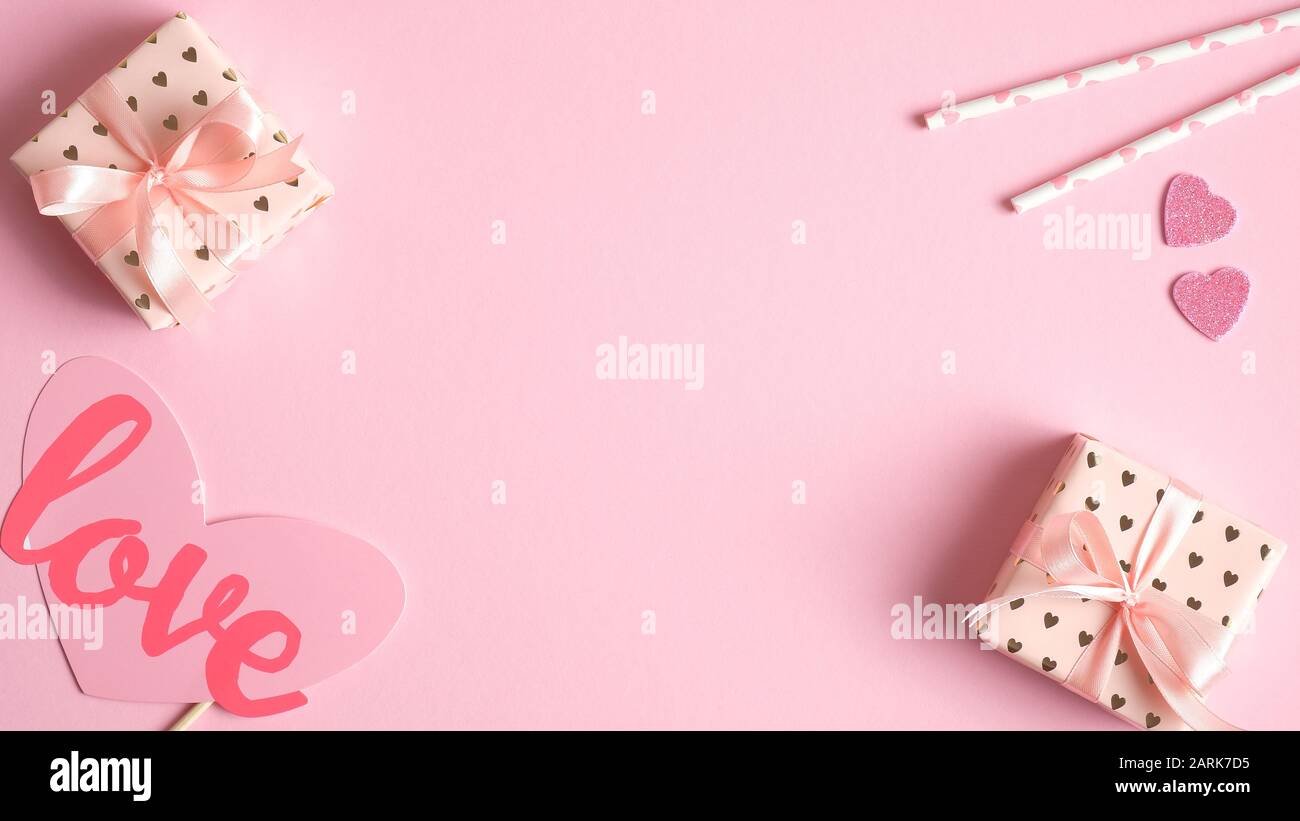 Hintergrund des Valentinstages mit Geschenkschachteln und Party-Requisiten in Rosa. Valentinstag-Feier-Konzept. Kreatives Design für Grußkarten, Partyeinstieg Stockfoto
