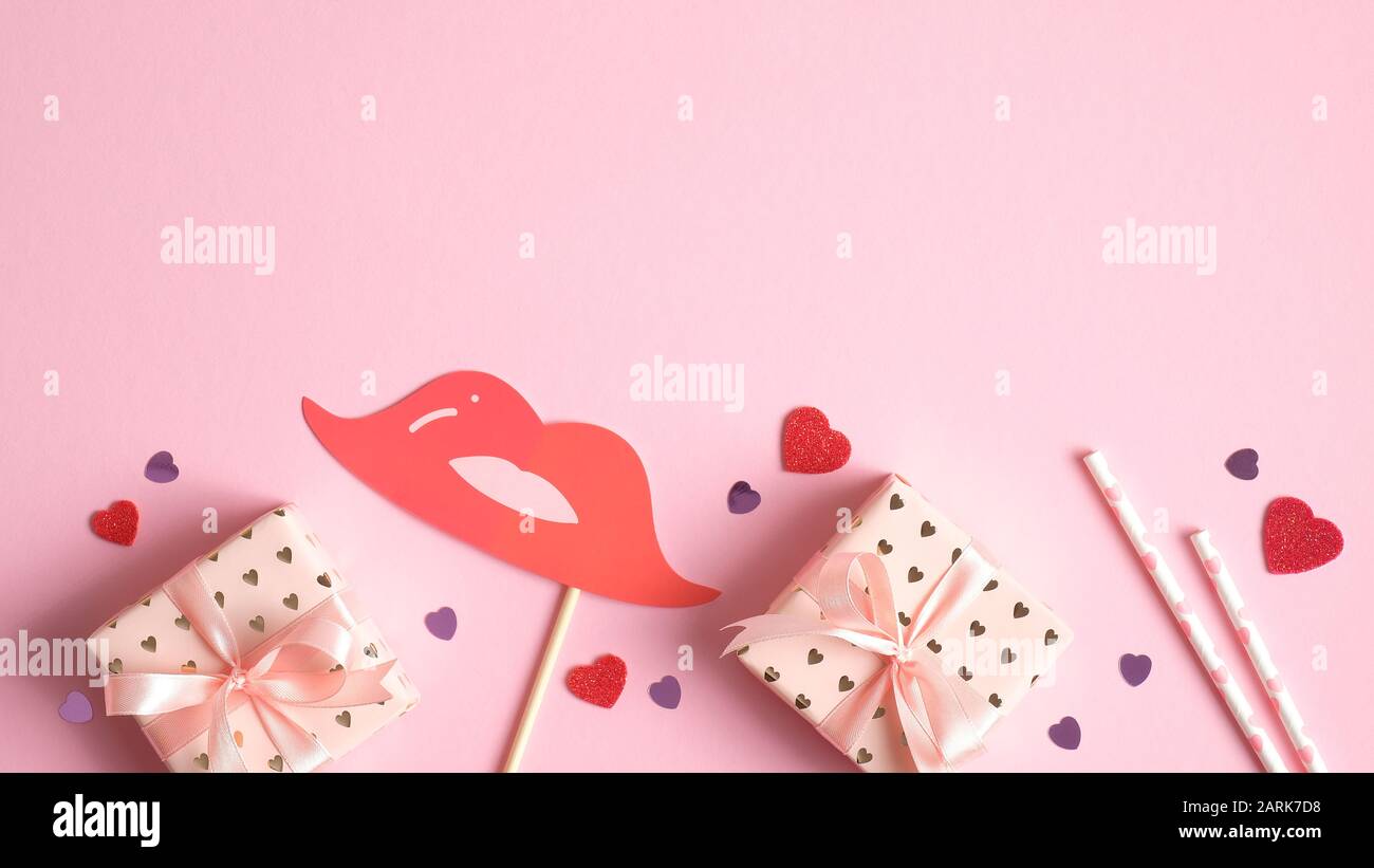 Vorlage für Valentinstag-Karte. Rahmen von Geschenkschachteln und Party-Requisiten auf pinkfarbenem Hintergrund. Valentinstag-Feier-Konzept. Kreatives Design für Stockfoto