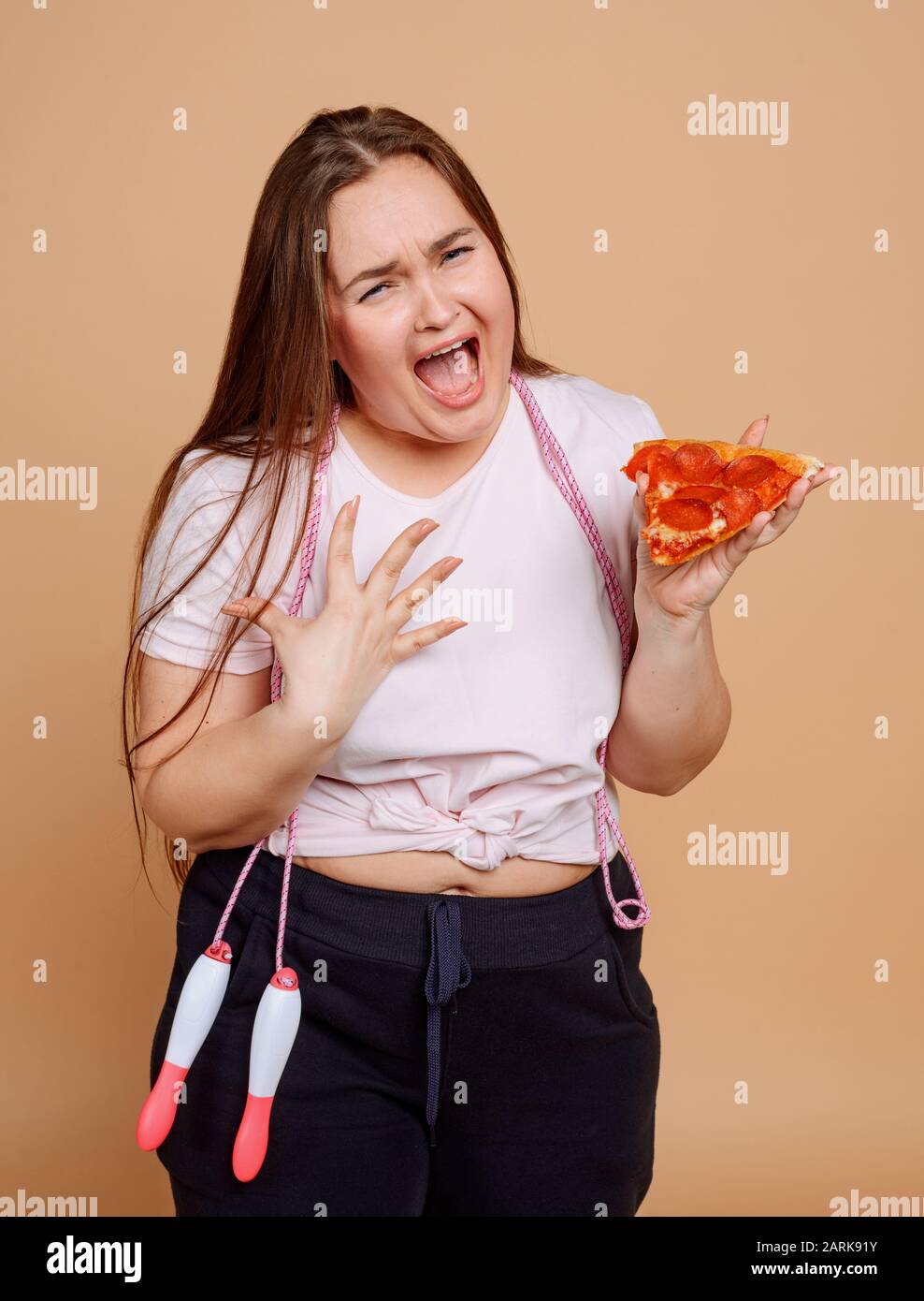 Übergewichtige Frau weinte, weil sie Pizza will Stockfoto