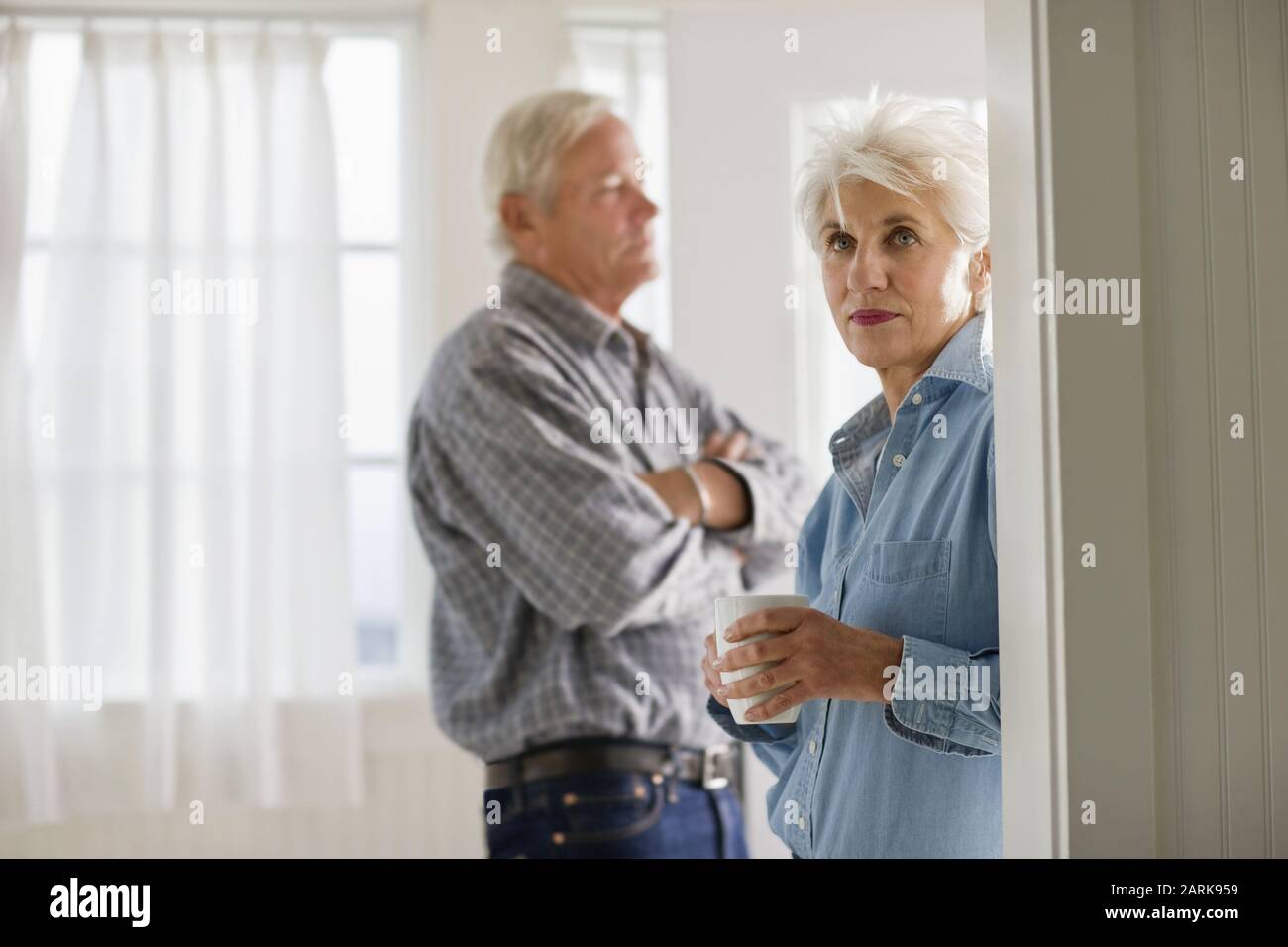 Reifen erwachsenen Paar stehend mit einem Drink in einem Raum. Stockfoto