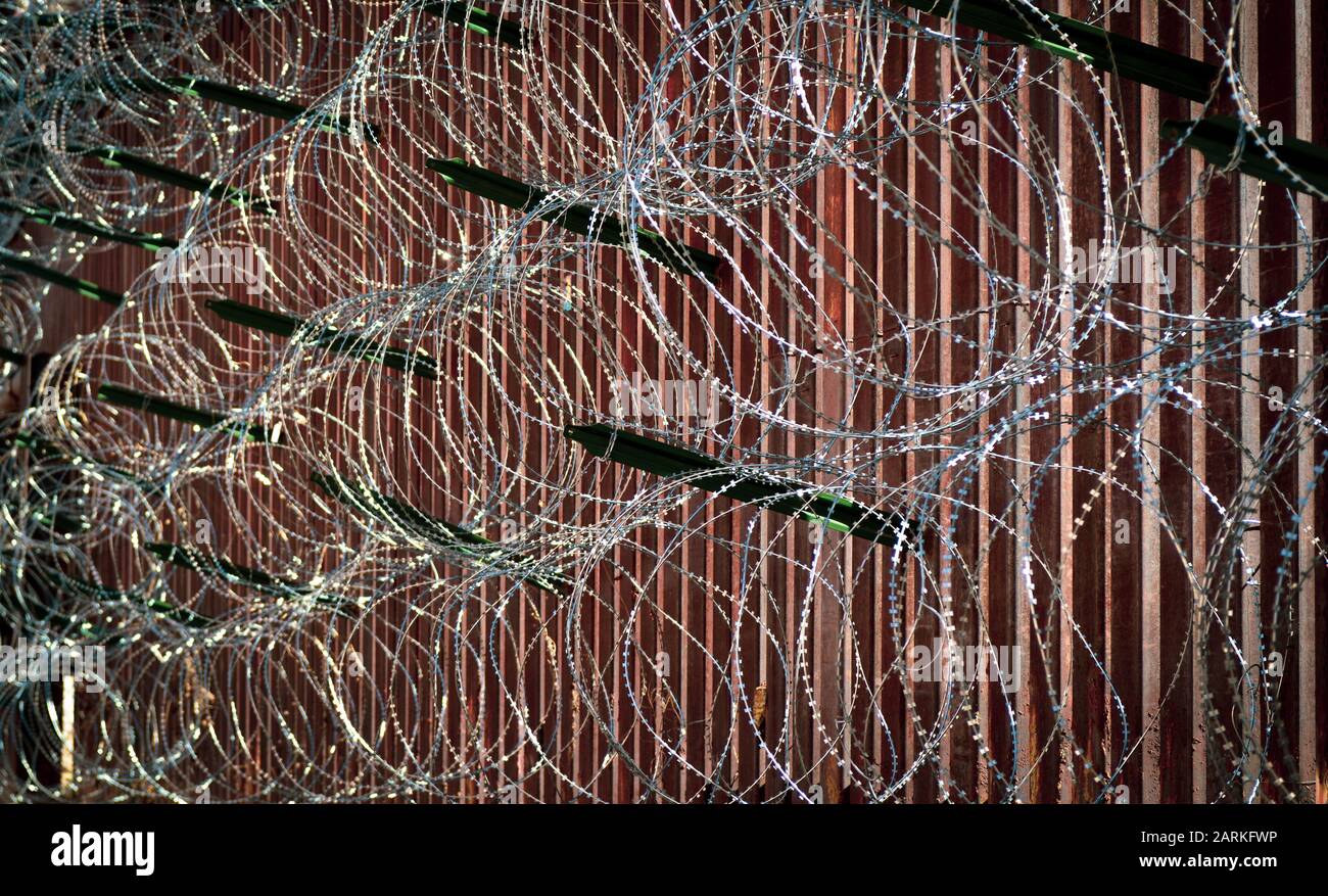 Nahaufnahme des internationalen Grenzzauns aus Metall in den USA/Mexiko mit Rasierdraht in Nogales, AZ, USA Stockfoto