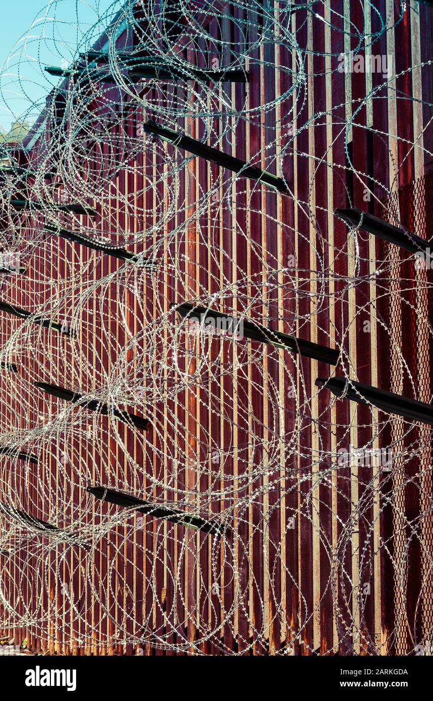 Nahaufnahme des internationalen Grenzzauns aus Metall in den USA/Mexiko mit Rasierdraht in Nogales, AZ, USA Stockfoto