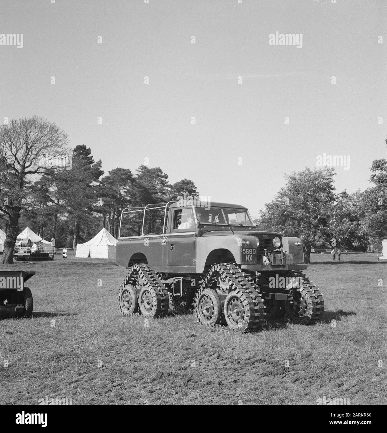 Lastwagen, Schienen, Zelte, Rasen, Bäume Datum: Undatierte Stichwörter: Bäume, Rasen, Raupen, Zelte, Lastwagen Stockfoto