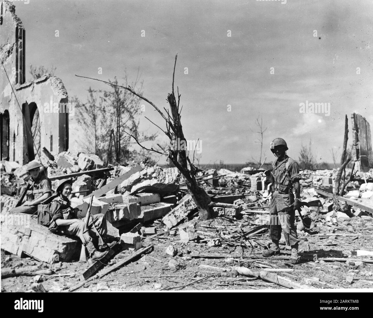 Verwüstungen in Balikpapan (Indie). Nachdem die Einheiten der Australian 7th Division und KNIL im Juli 1954 bei Balikpapan auf Borneo gelandet waren, ist dieser kleine Hund, der von einem KNIL-Militär gehalten wird, das einzige Lebewesen, das an diesem Ort gefunden wurde Anmerkung: Repronegativdatum: Juli 1945 Ort: Balikpapan, Indonesien, Indonesien, Niederländisch-Ostindien Stichwörter: Militär, Zerstörung Stockfoto