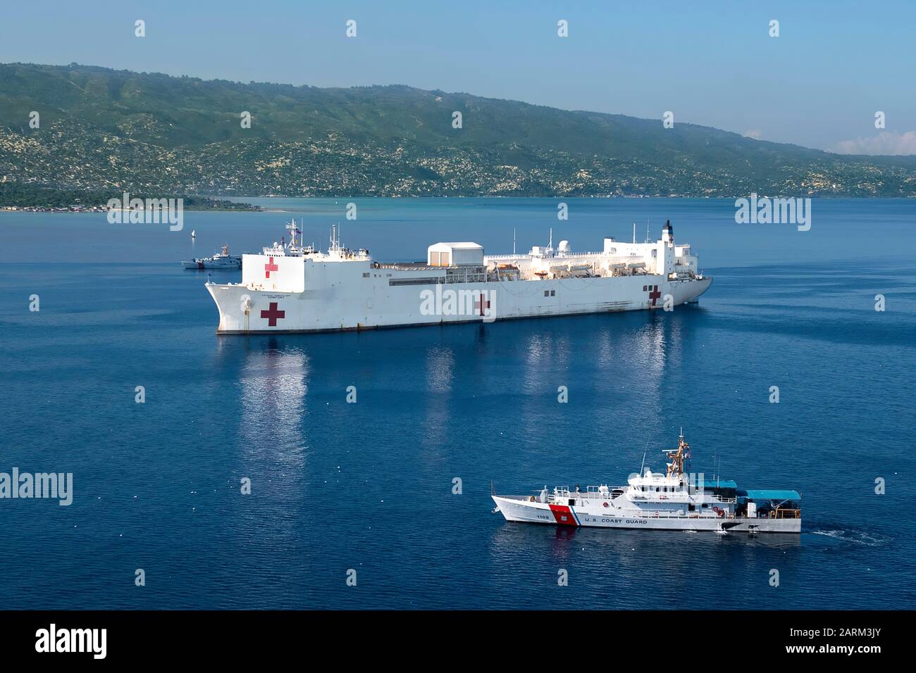 USCGC Margaret Norvell (WPC 1105), Front und USCGC Kathleen Moore (WPC 1109) segeln neben dem Hospitalschiff USNS Comfort (T-AH 20), da es vor der Küste von Port-Au-Prince, Haiti in Vorbereitung auf eine sechstägige medizinische Mission, 4. November 2019, verankert ist. Trost arbeitet mit Gesundheits- und Regierungspartnern in Mittelamerika, Südamerika und der Karibik zusammen, um auf dem Schiff und an landbasierten medizinischen Standorten für die Versorgung zu sorgen und dabei zu helfen, den Druck auf die nationalen medizinischen Systeme zu lindern, einschließlich derjenigen, die von einem Anstieg der grenzüberschreitenden Migranten angespannt werden. (USA Navy-Foto von Mass Communication Specialist 2. Cla Stockfoto