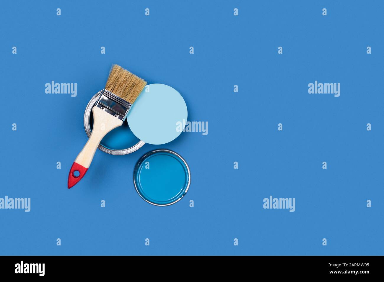 Foto für Präsentationsapartment Reparaturen. Blauer Hintergrund mit einer Holz-Quaste und einer Kreis- und LackierDose. Flaches Layout, Draufsicht, Kopierbereich. Stockfoto