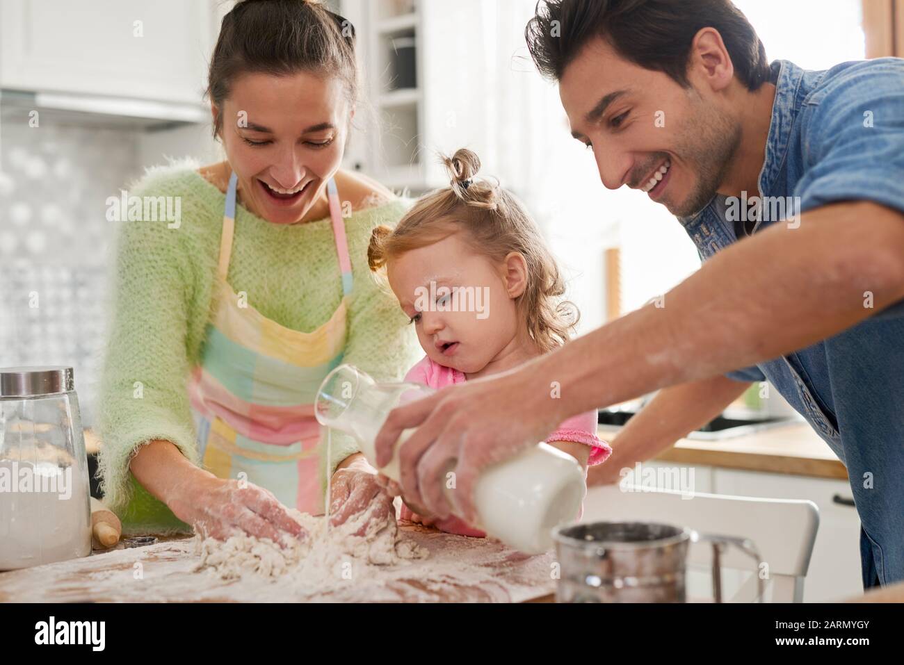 Tochter hilft Eltern beim Kochen Stockfoto