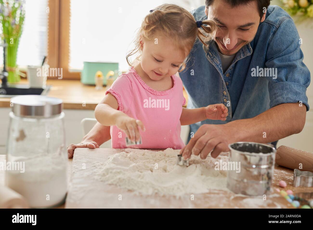 Töchter helfen Vater beim Backen Stockfoto