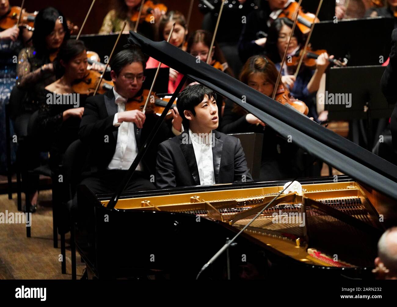 (200129) -- NEW YORK, 29. Januar 2020 (Xinhua) -- der chinesische Pianist Zhang Haochen (Front) führt "Rhapsody in Blue" mit dem Orchester während eines Lunar New Year Concert der New Yorker Philharmoniker in New York, den Vereinigten Staaten, 28. Januar 2020 auf. Die New Yorker Philharmoniker präsentierten am Dienstagabend ihr neuntes jährliches Lunar New Year Concert mit gefeierten und aufstrebenden Künstlern, die im Jahr der Ratte klingeln sollen. Zu dem Programm gehörten berühmte Musikstücke aus Amerika und Asien, ein Violinenkonzert The Butterfly Lovers mit dem amerikanischen Geiger Gil Shaham als Solist und George Gershwin's Rhapsody in Bl Stockfoto