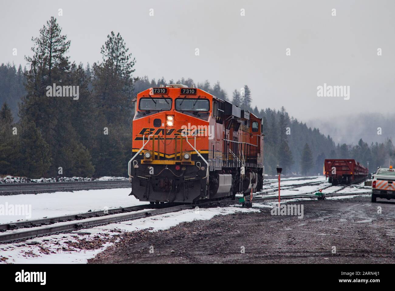 Eine schwarze, gelbe und orangefarbene BNSF-Lok, die im Leerlauf auf den Gleisen in der Stadt Troy, Montana, fuhr. Burlington Northern and Santa Fe Railway wurde in gebildet Stockfoto