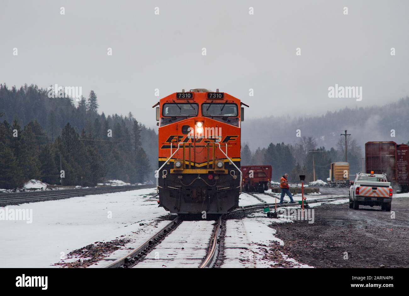 Eine schwarze, gelbe und orangefarbene BNSF-Lok, die im Leerlauf auf den Gleisen in der Stadt Troy, Montana, fuhr. Stockfoto