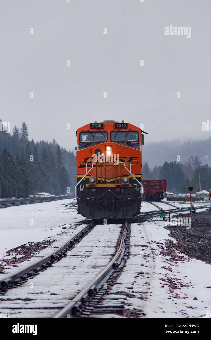 Eine schwarze, gelbe und orangefarbene BNSF-Lok, die im Leerlauf auf den Gleisen in der Stadt Troy, Montana, fuhr. Burlington Northern and Santa Fe Railway wurde in gebildet Stockfoto