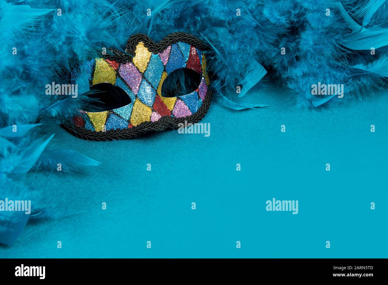 Bunte Partymaske mit blauen Federn auf blauem Hintergrund mit Platz für Kopien Stockfoto