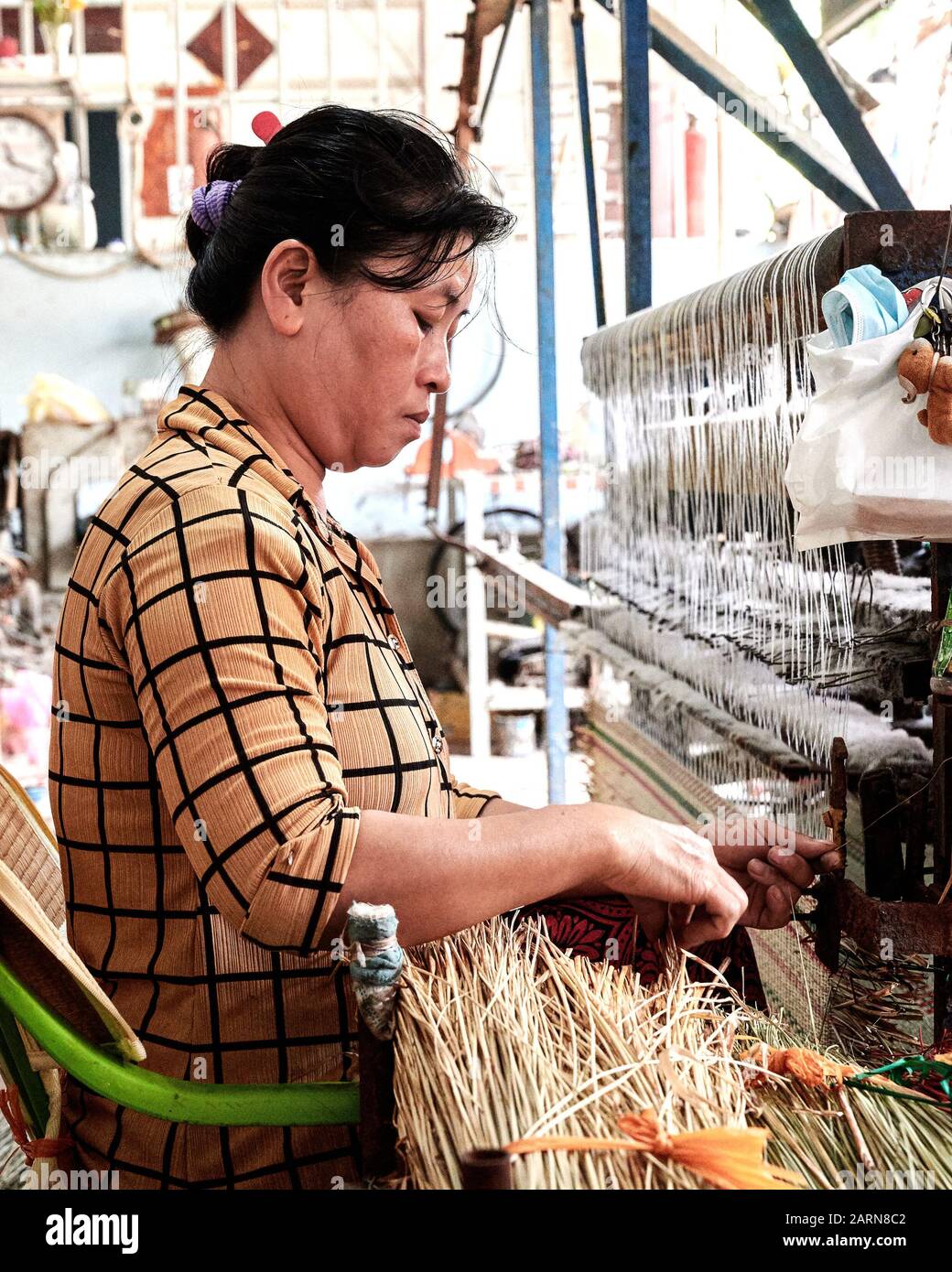 Traditioneller Rattan Weaver in Tan Chao. Ein erfahrener Weber bearbeitet die Maschine aus einem getrockneten Rattanbündel. Stockfoto