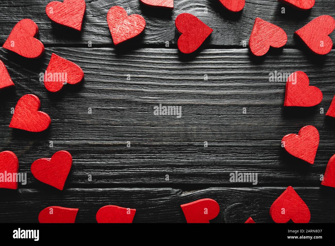 Herzrahmen auf dunklem rustikalem Holzhintergrund. Valentinstag gefeiert. Liebeskarte mit Kopierspeicher Stockfoto
