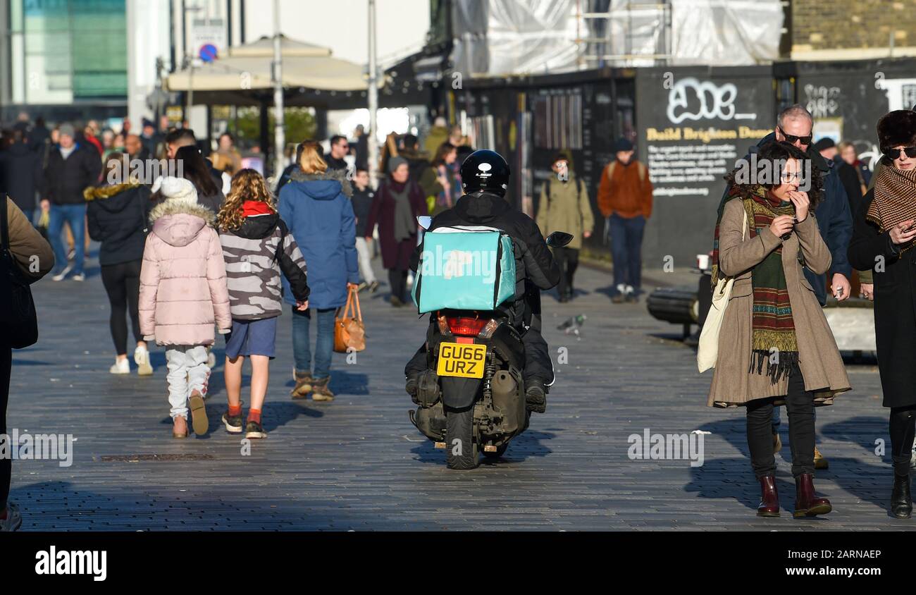 Ein Fahrer von Deliveroo auf einem Roller webt unter Fußgängern in Brighton  Stockfotografie - Alamy