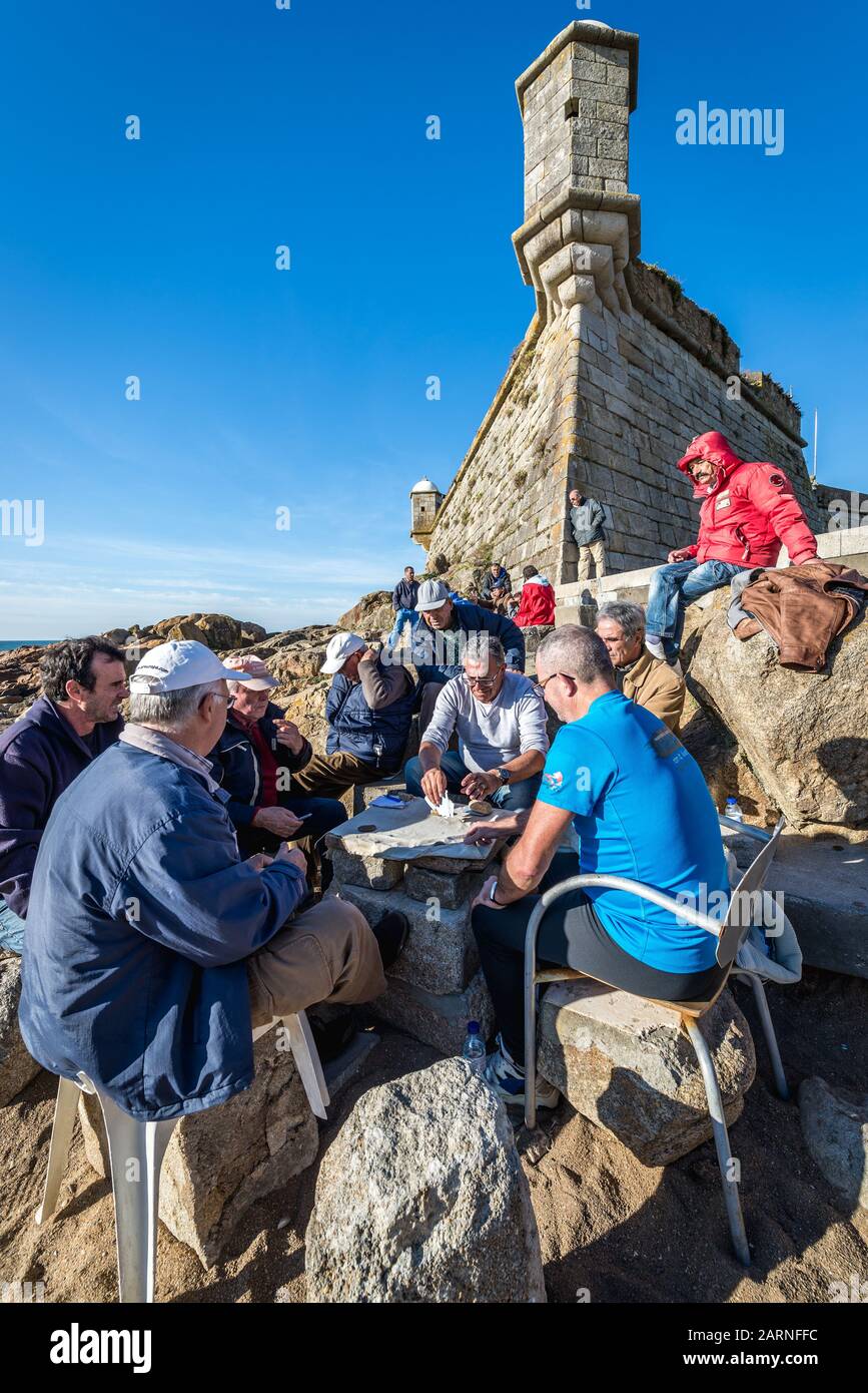 Gruppe von Männern spielt Karten neben Fort Sao Francisco Queijo (allgemein bekannt als Burg von Käse) in Nevogilde Zivilgemeinde von Porto, Portugal Stockfoto