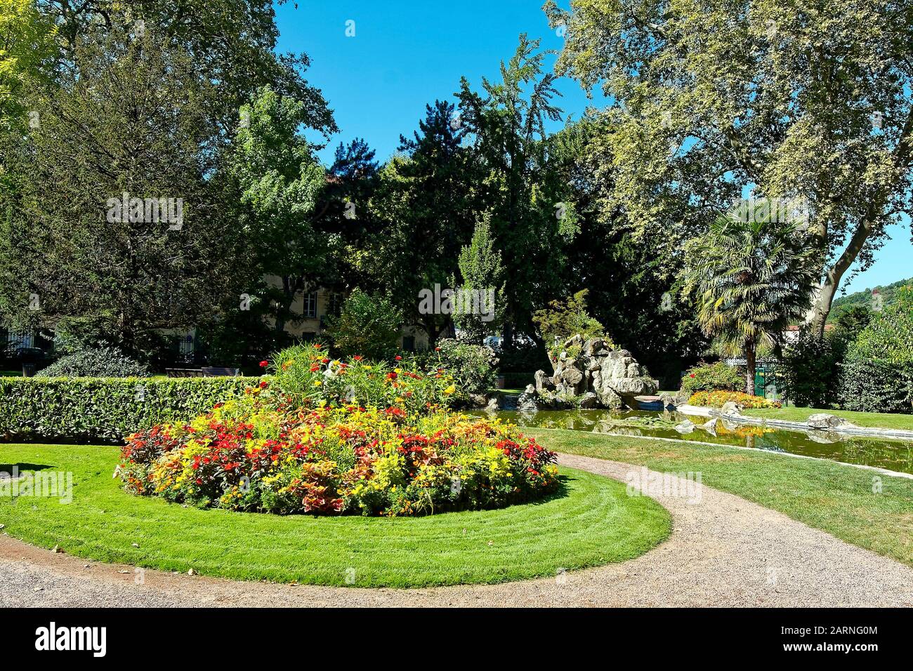 Garten, buntes Blumenbeet, rund, Pfad, Gras, Bäume, Wasser, friedlich, Place des Allobroges, Vienne, Frankreich, Sommer, horizontal Stockfoto