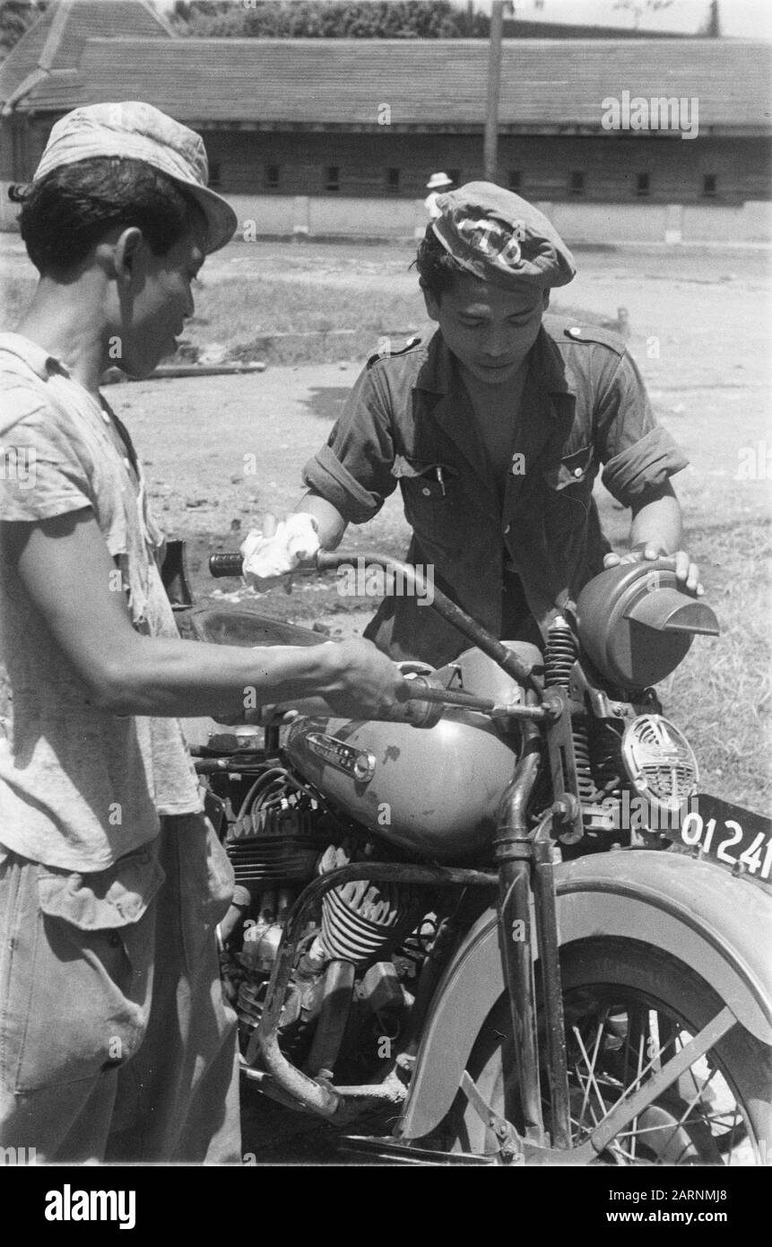 Technischer Dienst V-Brigade Zwei indonesische Männer, die mit einem Motorrad basteln. Der Richter hat die Abkürzung L.T.D. (Technischer Dienst der Armee) auf seinem Liegeplatz. Datum: April 1949 Ort: Indonesien, Niederländisch-Ostindien Stockfoto