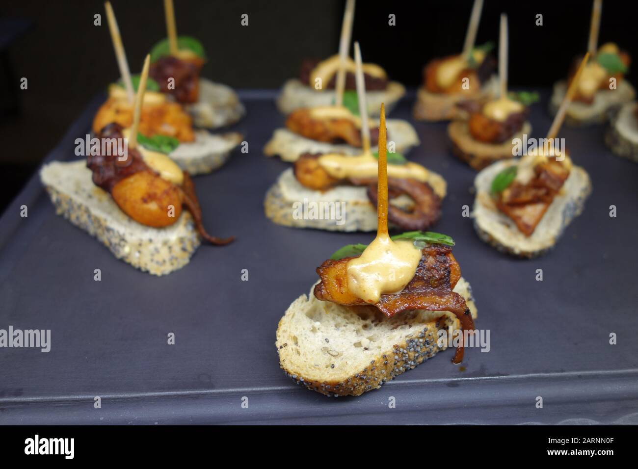 Kleine Octopus-Appetithäppchen/Snack "Panish Tapas" auf Geschnittenem Poppy Gebackenem Brot im Buffet im Azul Beach Resort Hotel, Puerto Morelos, Cancun. Stockfoto