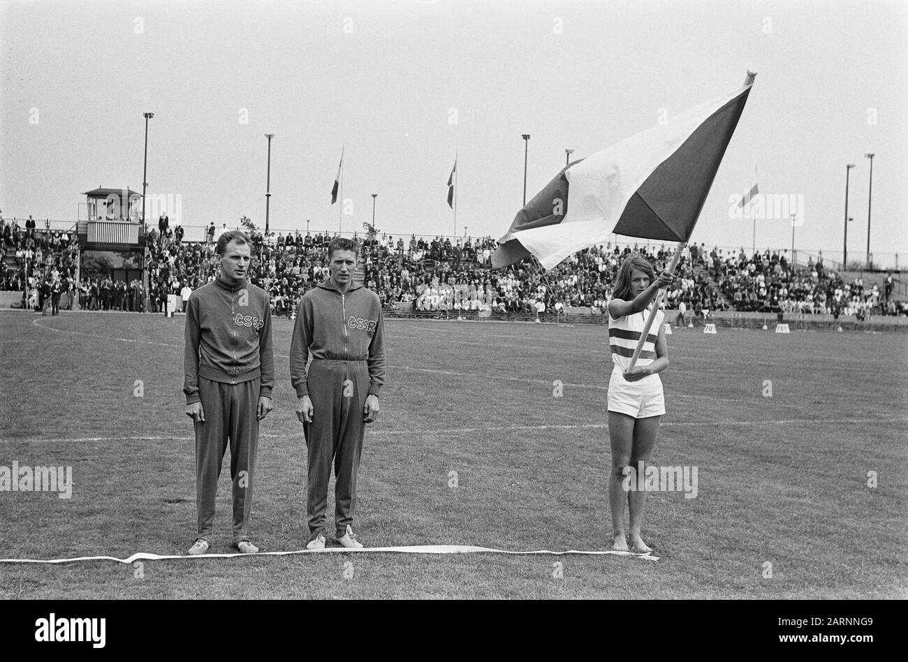 Six Lands Athletics in Enschede Flagparade Annotation: Links sind 2 tschechische Athleten auf der Anzeige Datum: 13. Juli 1963 Ort: Enschede Schlagwörter: Leichtathletik, Sport, Flaggenparaden Institutionenname: Six Countries Athletics Stockfoto