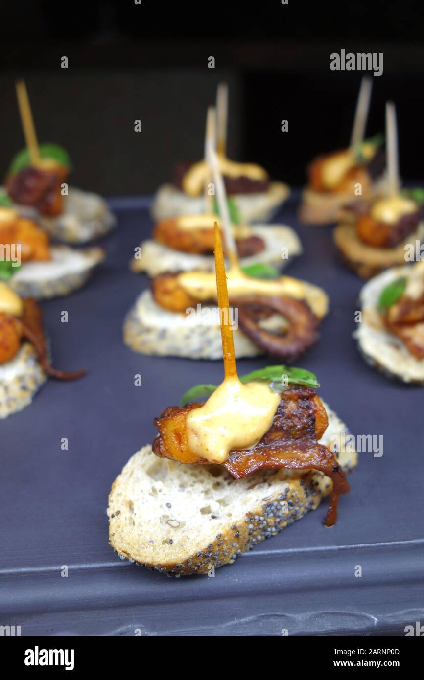 Kleine Octopus-Appetithäppchen/Snack "Panish Tapas" auf Geschnittenem Poppy Gebackenem Brot im Buffet im Azul Beach Resort Hotel, Puerto Morelos, Cancun. Stockfoto
