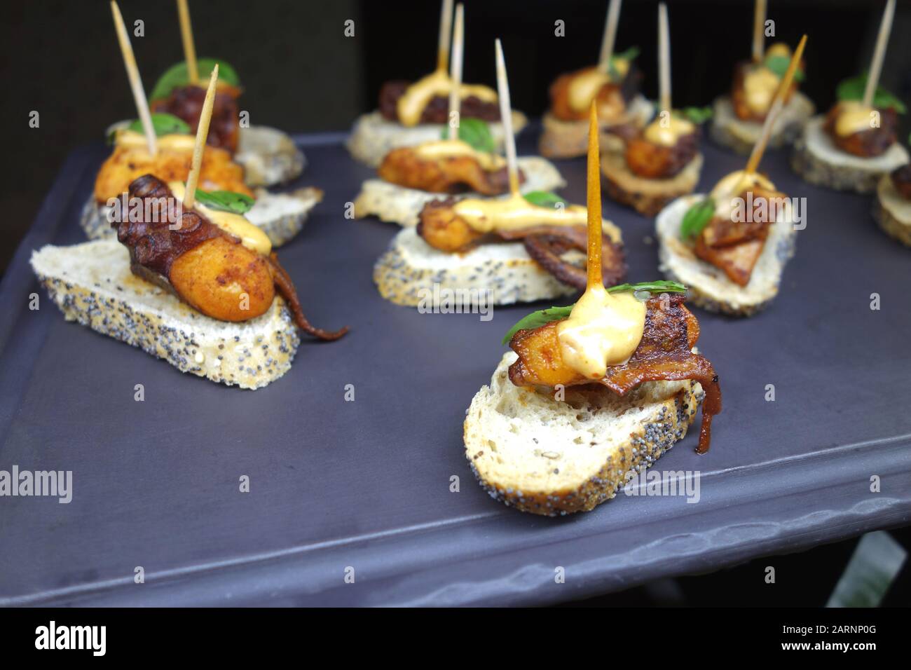 Kleine Octopus-Appetithäppchen/Snack "Panish Tapas" auf Geschnittenem Poppy Gebackenem Brot im Buffet im Azul Beach Resort Hotel, Puerto Morelos, Cancun. Stockfoto