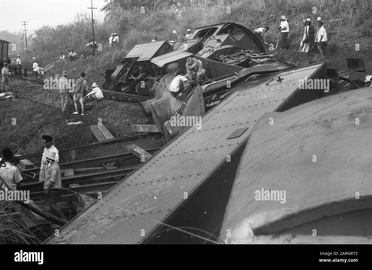 Zugunfall Poerwakarta Freitagnachmittag, 22. Oktober 1948 der Schnellzug Batavia-Bandoeng in 16,50 Stunden zwei Kilometer südlich von Poerwakarta bei Bengoal entgleiste, weil die Schienen von einer Bande von Terroristen über eine Distanz von 20 Metern gebrochen worden waren. Unmittelbar nach der Entgleisung wurde der Zug von schätzungsweise 50 Mann, die mit automatischen Waffen und Gewehren besetzt waren, unter Beschuss genommen, wobei acht Menschen getötet und 23 verwundet wurden. Da eine beträchtliche Anzahl von Soldaten mit dem Zug unterwegs war, konnte das Feuer der Bande fast sofort beantwortet werden. Das verhinderte Schlimmeres. Übersicht über die Stockfoto