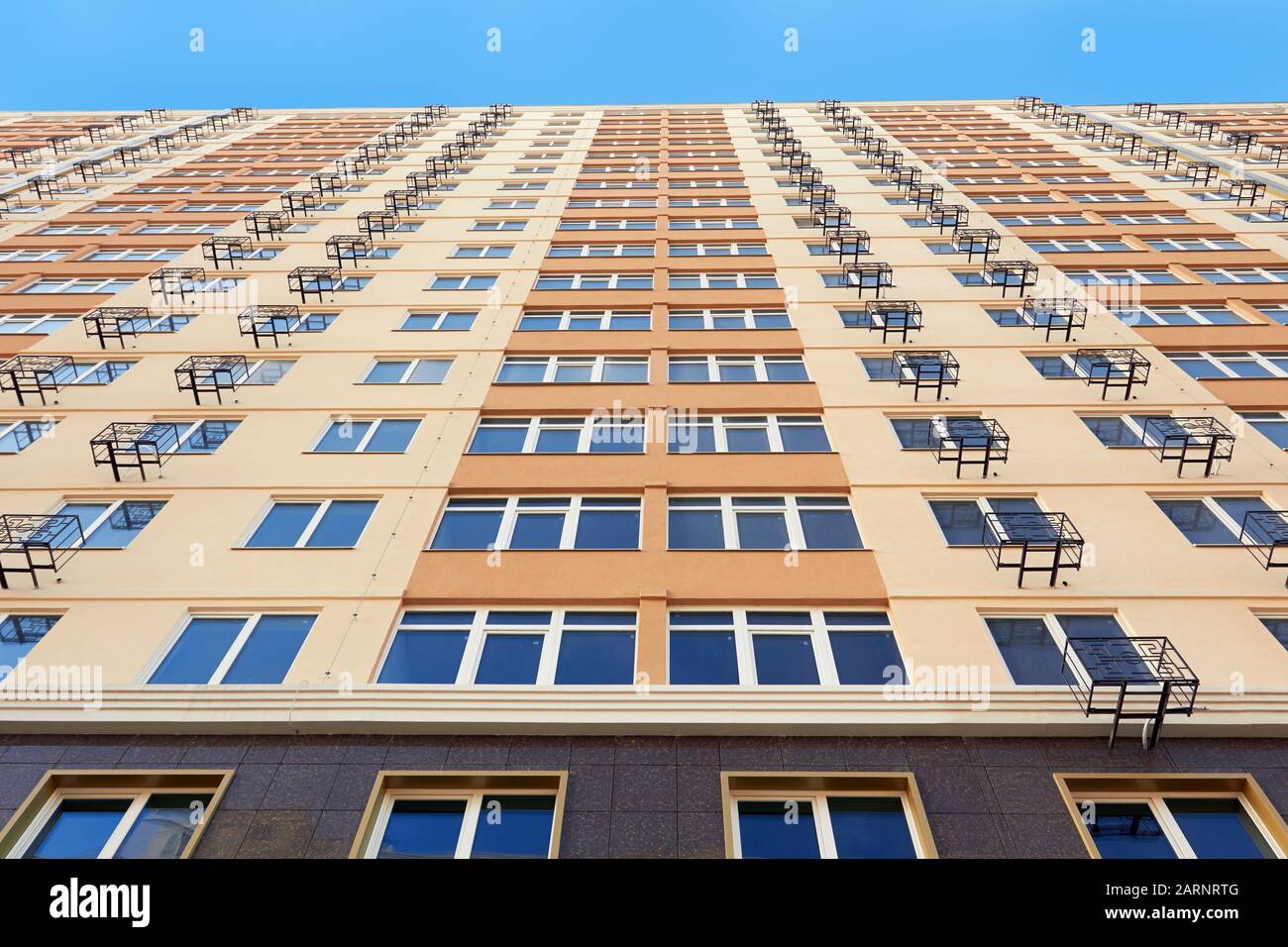 Blick von unten auf das gelbe Apartmentgebäude Stockfoto