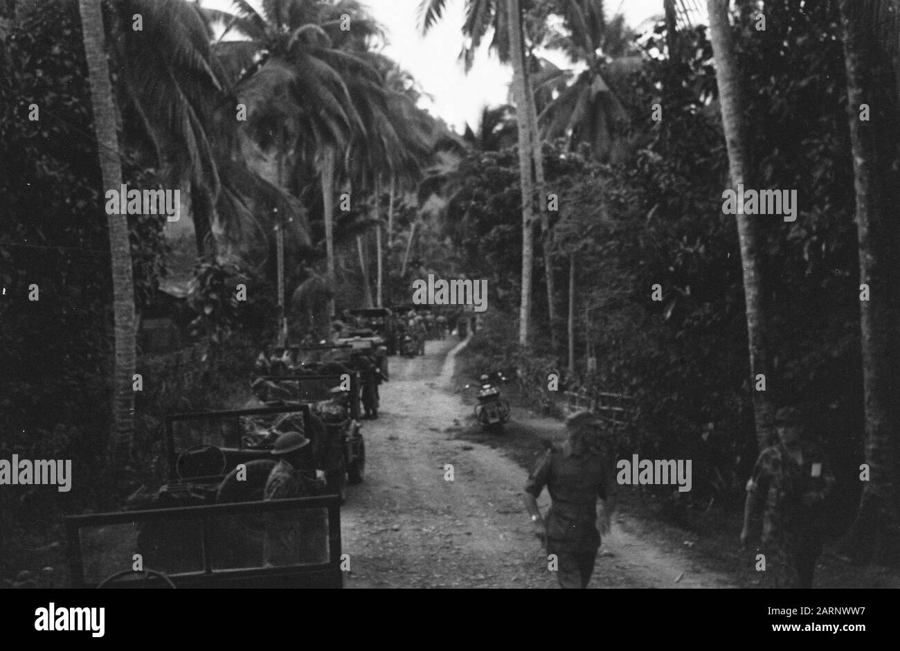 Padang [eine Militärsäule steht noch auf einer Straße mit Palmen] Datum: Juli 1947 Ort: Indonesien, Niederländische Ostindien Stockfoto