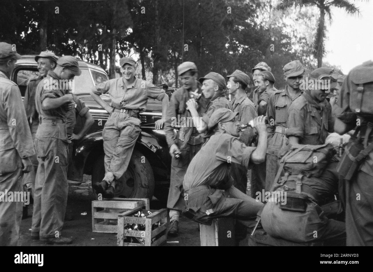 Nach Kediri Für die lange Reise nach Kediri (Ostjava) kommen diese Infantrymen zuerst mit einem kühlen Getränk Anmerkung: Der Sarg mit Flaschen Alkohol stammt von Heinthe Malang Datum: 24. Dezember 1948 Ort: Indonesien, Niederländische Ostindien Stockfoto