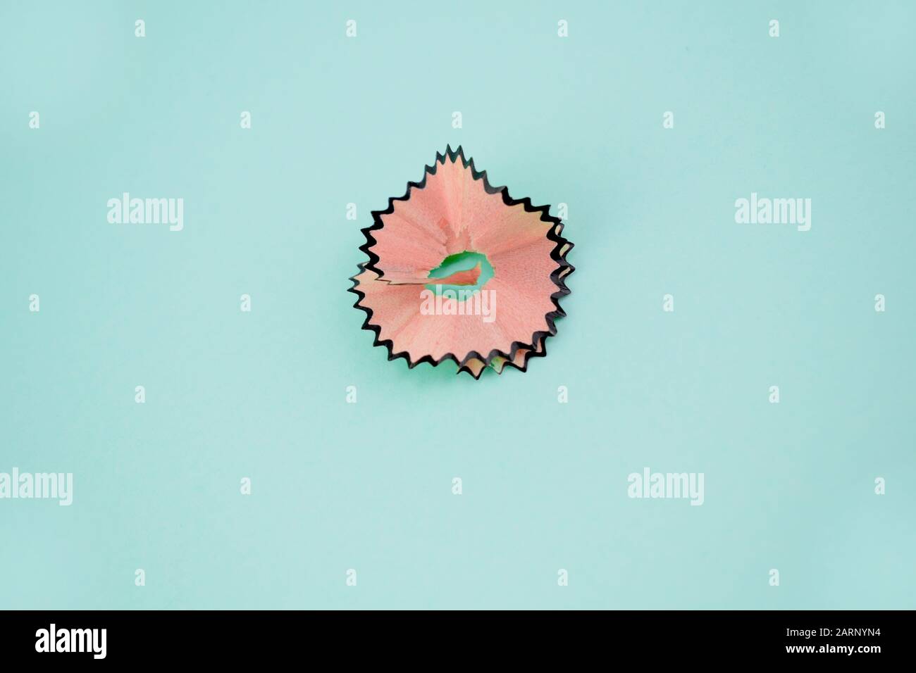 Ein Stück brauner Bleistiftzerrasur auf hellblauem Papier Stockfoto