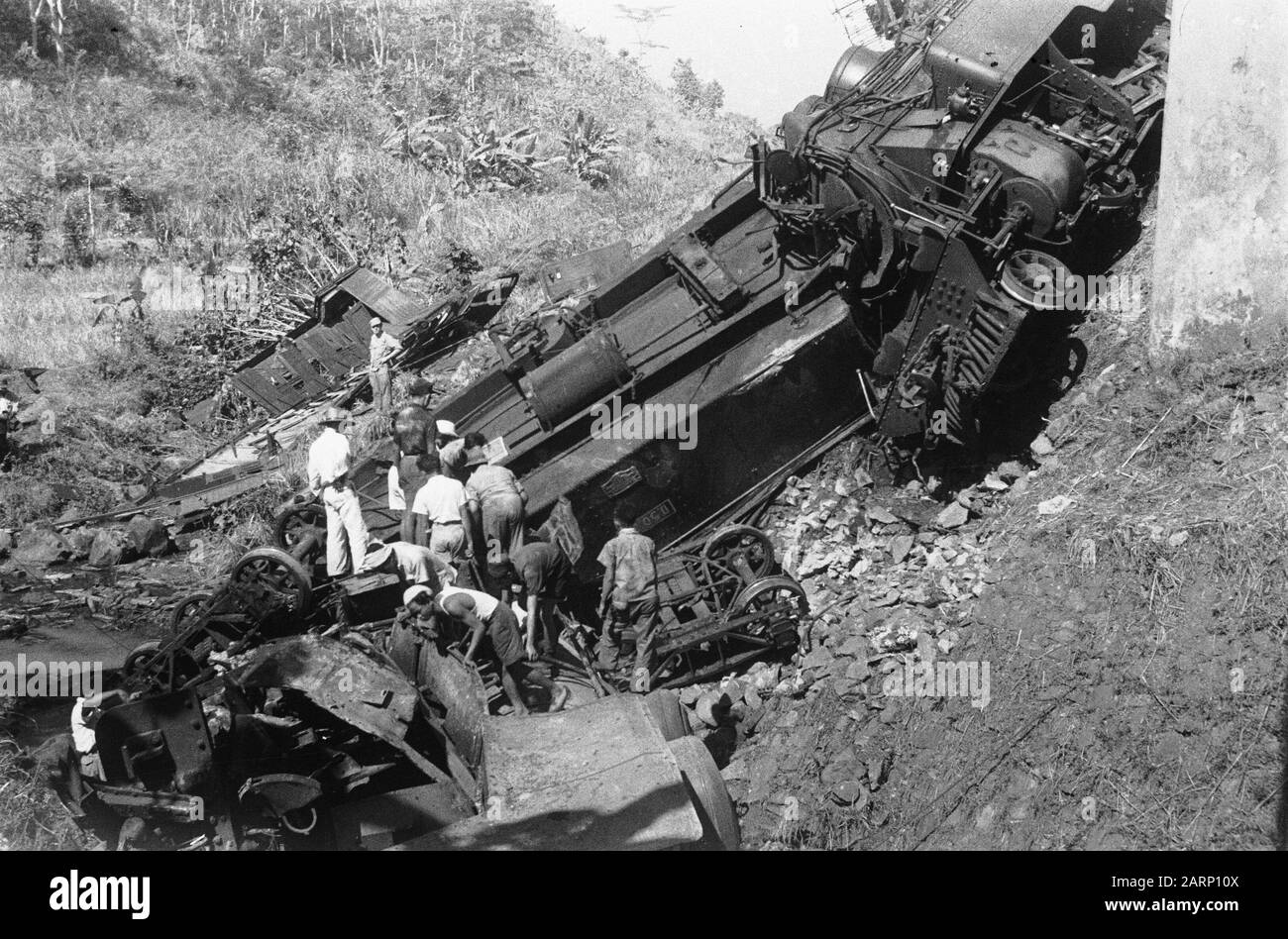 Eisenbahnunfall Poerwakarta am Samstagabend, 21. August 1948 um etwa 22.20 Uhr befindet sich in der Nähe der Eisenbahnbrücke von Daan auf der Strecke zwischen Bandoeng und Poerwakarta ein Güterzug, der durch Sabotage einer Bande entgleist ist. Die beiden Lokomotiven, ein Pkw und ein Kesselwagen stürzten in eine 15 Meter tiefe Schlucht. Fünf Menschen wurden getötet und sieben verletzt, darunter der Fahrer und zwei Stoker. Der Unfall, der etwa fünf Kilometer vor Poerwakarta passierte, ist darauf zurückzuführen, dass die Schienen über eine große Strecke aufgebrochen waren. Mitarbeiter der S.S. vielbeschäftigten Bergkörper Datum: 22. August 1948 L Stockfoto