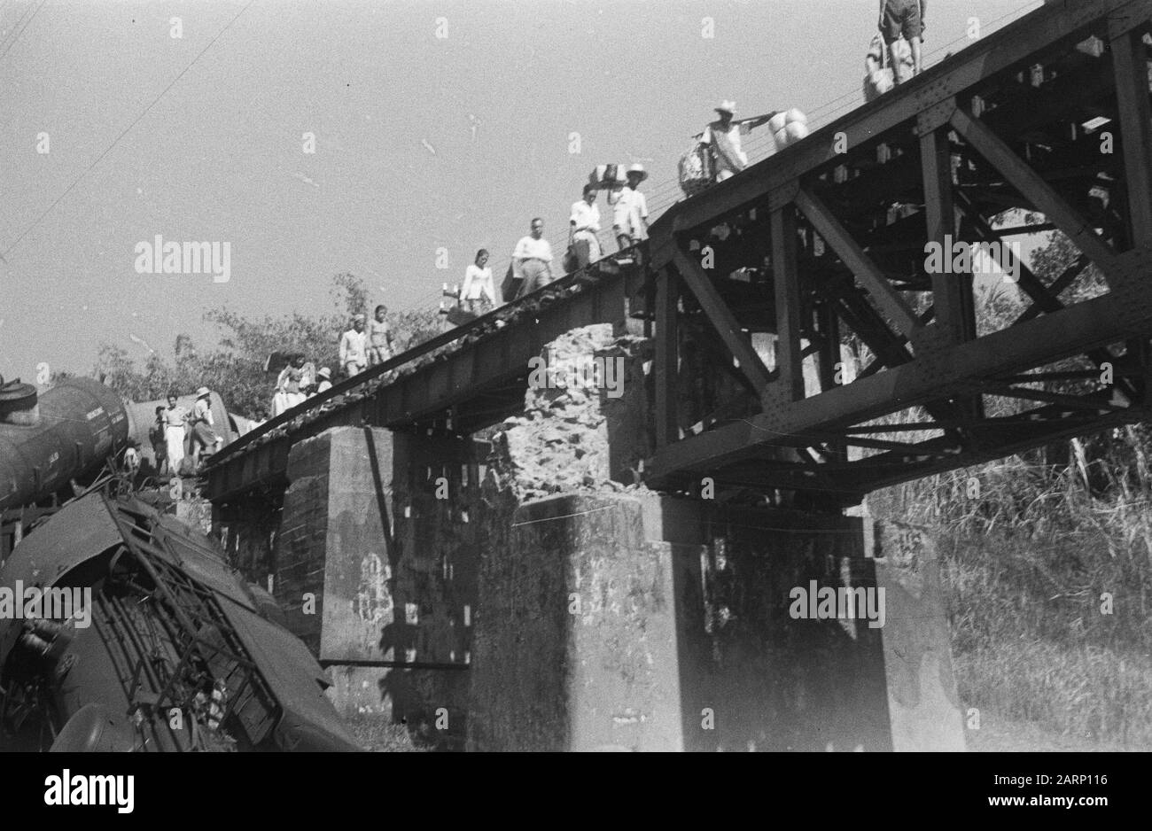 Eisenbahnunfall Poerwakarta am Samstagabend, 21. August 1948 um etwa 22.20 Uhr befindet sich in der Nähe der Eisenbahnbrücke von Daan auf der Strecke zwischen Bandoeng und Poerwakarta ein Güterzug, der durch Sabotage einer Bande entgleist ist. Die beiden Lokomotiven, ein Pkw und ein Kesselwagen stürzten in eine 15 Meter tiefe Schlucht. Fünf Menschen wurden getötet und sieben verletzt, darunter der Fahrer und zwei Stoker. Der Unfall, der etwa fünf Kilometer vor Poerwakarta passierte, ist darauf zurückzuführen, dass die Schienen über eine große Strecke aufgebrochen waren. Die Fahrgäste der später vorbeifahrenden Züge mussten beim br Stockfoto