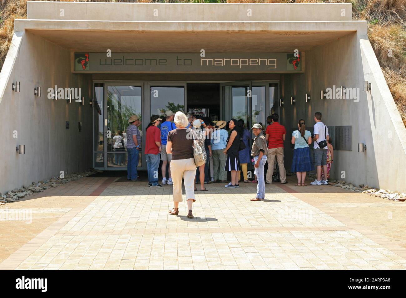 Touristen, die zu Fuß die Eingangstür der Wiege der Menschheit, Maropeng, Gauteng, Südafrika, erreichen. Stockfoto