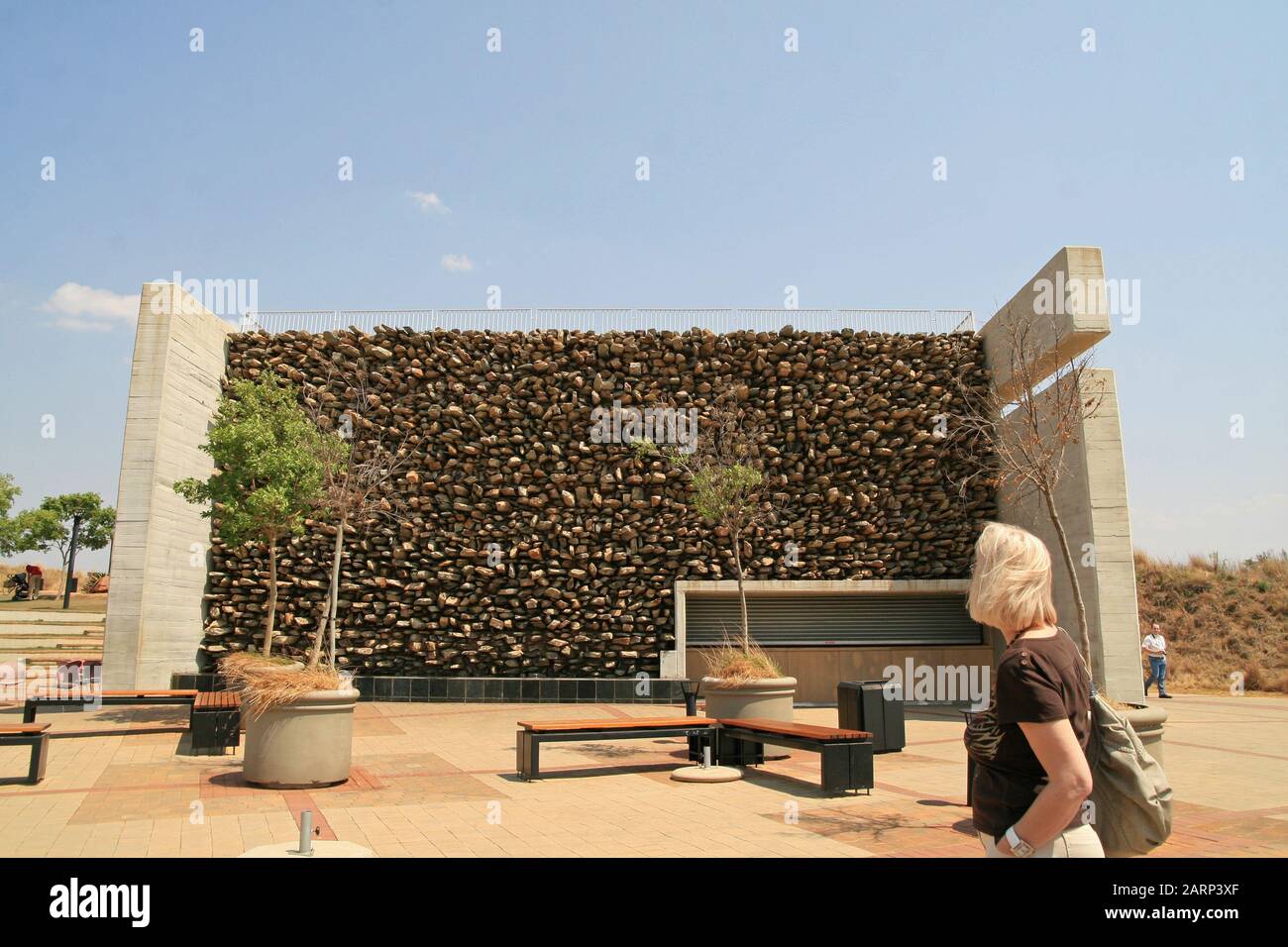 Touristen beim Bau mit Felswand, an Der Wiege der Menschheit, Maropeng, Gauteng, Südafrika. Stockfoto