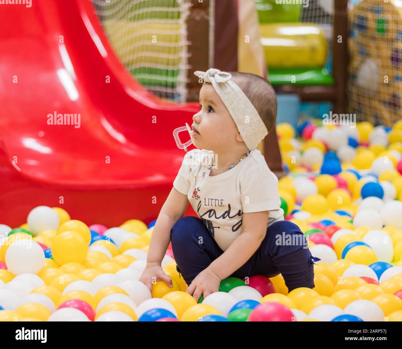 Ein süßes kleines Mädchen, das auf dem Indoor-Spielplatz in einem Einkaufszentrum spielt. Stockfoto