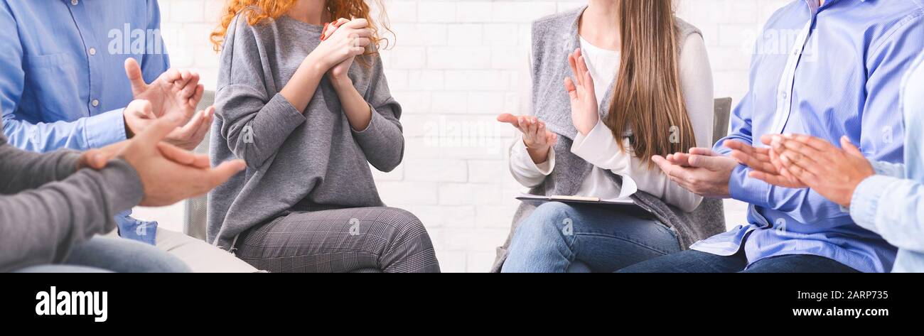 Verschiedene, nicht erkennbare Menschen, die Frauen bei Gruppentherapiesitzungen applaudieren Stockfoto